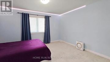 Ottawa apartment for rent - A bedroom with a purple bedspread and a window with blue curtains.