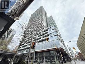 Toronto (Church-Yonge Corridor) condo for rent - A tall building with many windows is the main focus of the image.