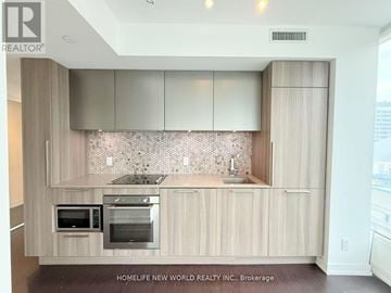Toronto (Church-Yonge Corridor) condo for rent - A modern kitchen with wooden cabinets and stainless steel appliances.