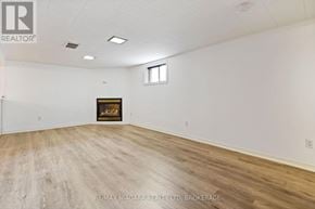 St. Catharines (Downtown) apartment for rent - A large, empty room with a fireplace and wood flooring.