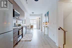 Toronto (Newtonbrook East) townhouse for rent - A modern kitchen with a refrigerator on the left and a dining area in the middle.