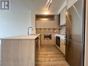 Toronto (Regent Park) condo for rent - A modern kitchen with wooden cabinets and stainless steel appliances.