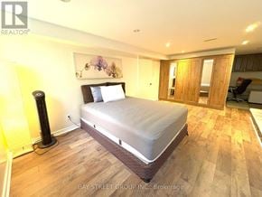 Toronto (Markland Wood) apartment for rent - A bedroom with a bed, wooden flooring, and a painting on the wall.