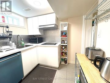 Toronto (Markland Wood) apartment for rent - A kitchen with white cabinets and a blue dishwasher.