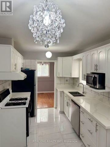 Mississauga (Meadowvale) apartment for rent - A white kitchen with a chandelier hanging from the ceiling.