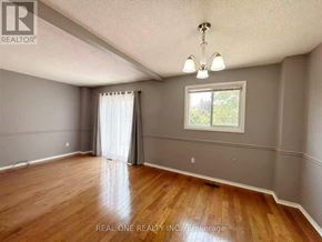Mississauga (Meadowvale) apartment for rent - A room with wooden floors and a window with white curtains.