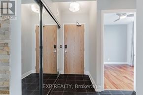 Toronto (South Parkdale) condo for rent - A hallway with wooden doors and a stone wall.