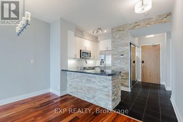 Toronto (South Parkdale) condo for rent - A kitchen with a stone counter and wooden floors.