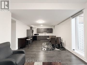 Pickering (Highbush) apartment for rent - A living room with a grey couch and a wooden floor.