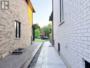 Pickering (Highbush) apartment for rent - A narrow alley with a brick building on the left and a white building on the right.
