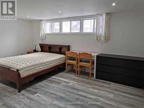 Toronto (Tam O'shanter-Sullivan) apartment for rent - A bedroom with a large bed and a wooden chair.