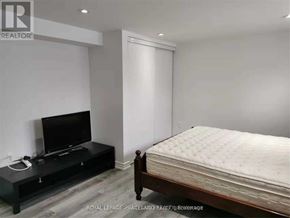 Toronto (Tam O'shanter-Sullivan) apartment for rent - A bedroom with a bed, a television, and a black console table.