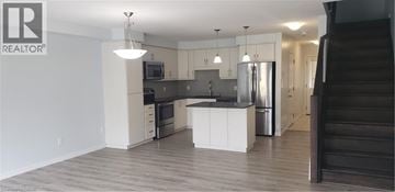 Kitchener townhouse for rent - A large open kitchen and living room with a staircase on the right.