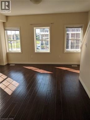 Kitchener townhouse for rent - A room with wooden floors and three windows.