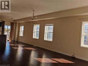 Kitchener townhouse for rent - A room with wooden floors and three windows.