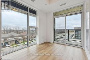 Hamilton (Waterdown) condo for rent - A room with a view of a street and houses through large windows.