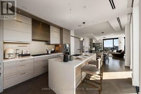 Toronto (Forest Hill South) condo for rent - A modern kitchen with a large island and a dining area.