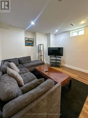 Mississauga (Lisgar) apartment for rent - A living room with a grey couch and a television.