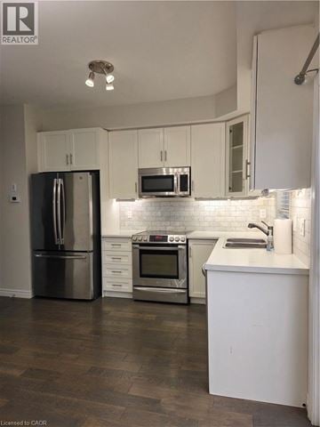 Ancaster townhouse for rent - A kitchen with white cabinets and a stainless steel refrigerator.