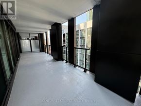 Toronto (Kensington-Chinatown) condo for rent - A long hallway with a glass wall on one side and a black wall on the other.