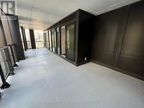 Toronto (Kensington-Chinatown) condo for rent - A long hallway with a carpeted floor and a row of windows on the left side.
