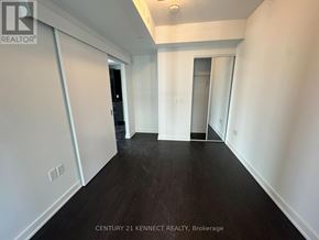 Toronto (Kensington-Chinatown) condo for rent - A long hallway with a door on the left and a window on the right.