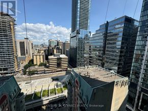 Toronto (Kensington-Chinatown) condo for rent - A cityscape with a mix of modern and older buildings under a clear sky.