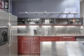 West Grey apartment for rent - A modern kitchen with stainless steel appliances and red cabinets.