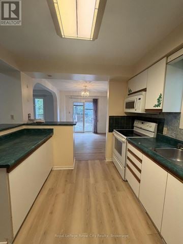 Guelph (Kortright West) apartment for rent - A kitchen with white cabinets and a green countertop.