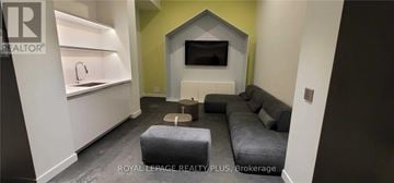 Toronto (Mount Pleasant West) condo for rent - A living room with a grey couch and a television on the wall.