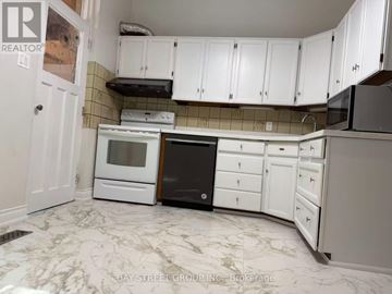 Toronto (Woburn) apartment for rent - A kitchen with white cabinets and a black oven.