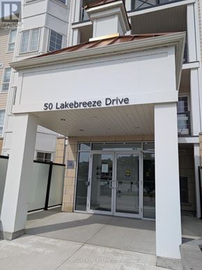 Clarington (Newcastle) condo for rent - The entrance to a building with a glass door and a sign that reads "50 Lakebreeze Drive".