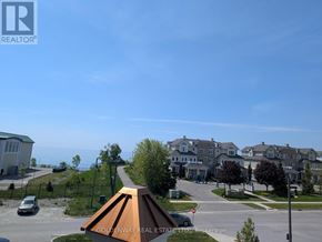 Clarington (Newcastle) condo for rent - A real estate company logo is displayed on a building in a residential area.