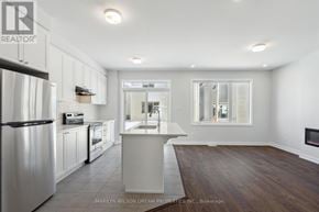 Ottawa townhouse for rent - A spacious kitchen with white cabinets and a wooden floor.