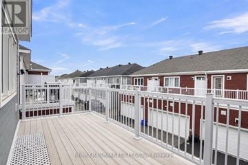 Ottawa townhouse for rent - A balcony with a white railing and a red building in the background.