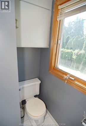 Windsor apartment for rent - A white toilet in a small bathroom with a window.