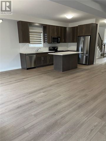 Thorold (Confederation Heights) apartment for rent - A modern kitchen with dark wood cabinets and stainless steel appliances.