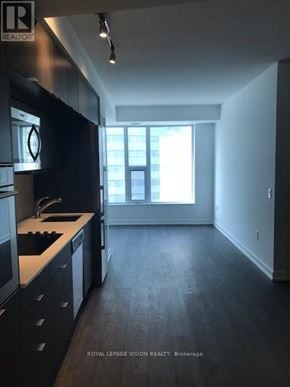Toronto (Waterfront Communities) condo for rent - A kitchen with black cabinets and a white countertop.