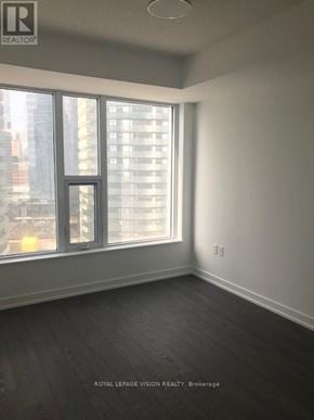 Toronto (Waterfront Communities) condo for rent - A room with a large window and a view of a city skyline.