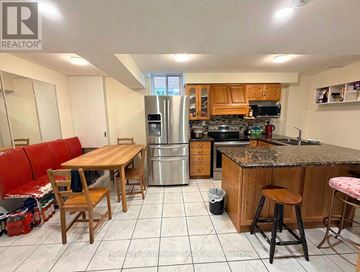 Mississauga (Central Erin Mills) apartment for rent - A kitchen with a table and chairs and a refrigerator.