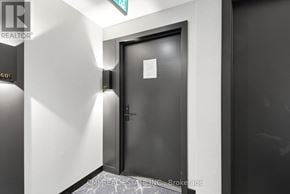 Toronto (Wychwood) condo for rent - A black door with a sign on it in a room.