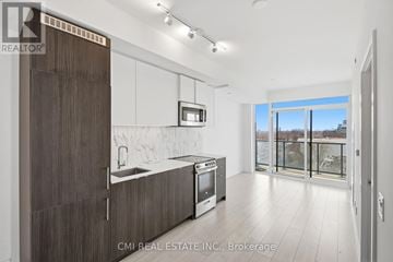 Toronto (Wychwood) condo for rent - A modern kitchen with dark wood cabinets and a white countertop.