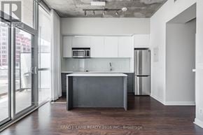 Toronto (Waterfront Communities) condo for rent - A modern kitchen with white cabinets and a dark island.