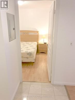 Toronto (Waterfront Communities) condo for rent - A bedroom with a bed, nightstand and lamp.