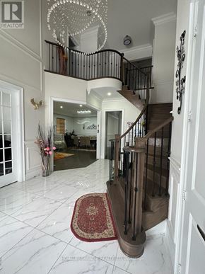 Brampton (Toronto Gore Rural Estate) apartment for rent - A foyer with a staircase and a chandelier.