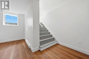 Brampton (Northwest Brampton) apartment for rent - A white room with wooden floors and a staircase leading to the second floor.
