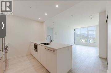 Coquitlam apartment for rent - A modern kitchen with white cabinets and a large island.