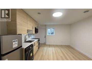 Burnaby townhouse for rent - A kitchen with a refrigerator and a washing machine.