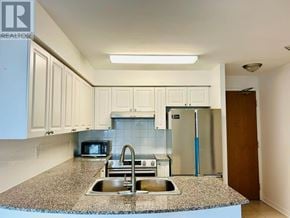Toronto (Willowdale West) condo for rent - A kitchen with granite countertops and white cabinets.