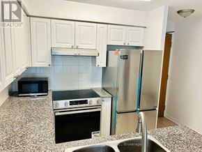 Toronto (Willowdale West) condo for rent - A kitchen with a refrigerator, microwave, oven, and sink.